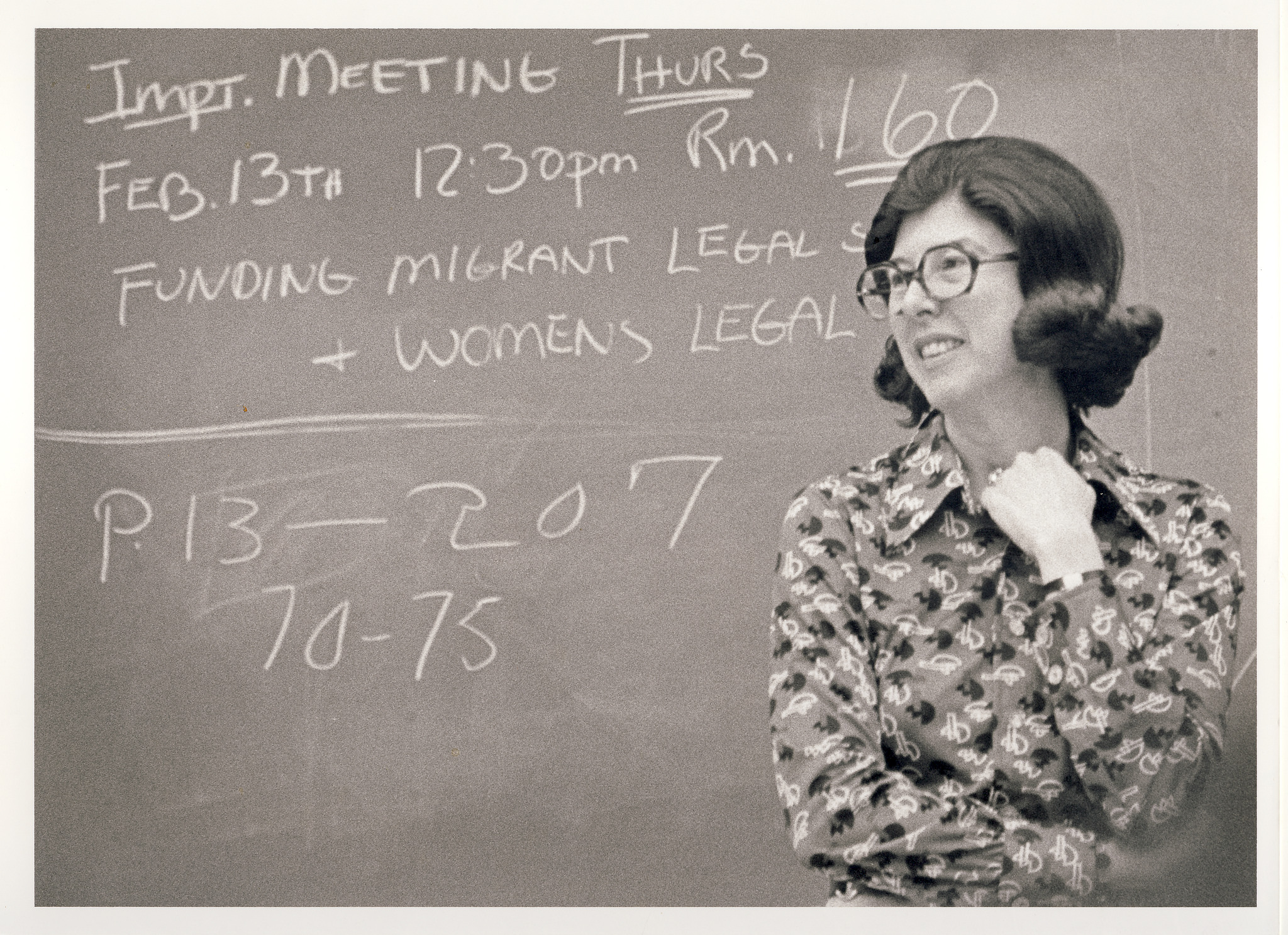 Photo: Herma Hill Kay standing in front of a chalk board smiling